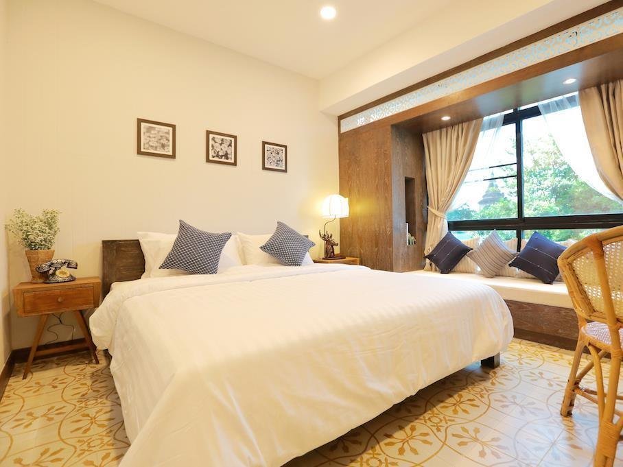 Double bed and window seating in a private room at Amaka Bed and Breakfast