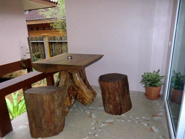 Wooden table and stools on a bungalow terrace at Baan Long Beach
