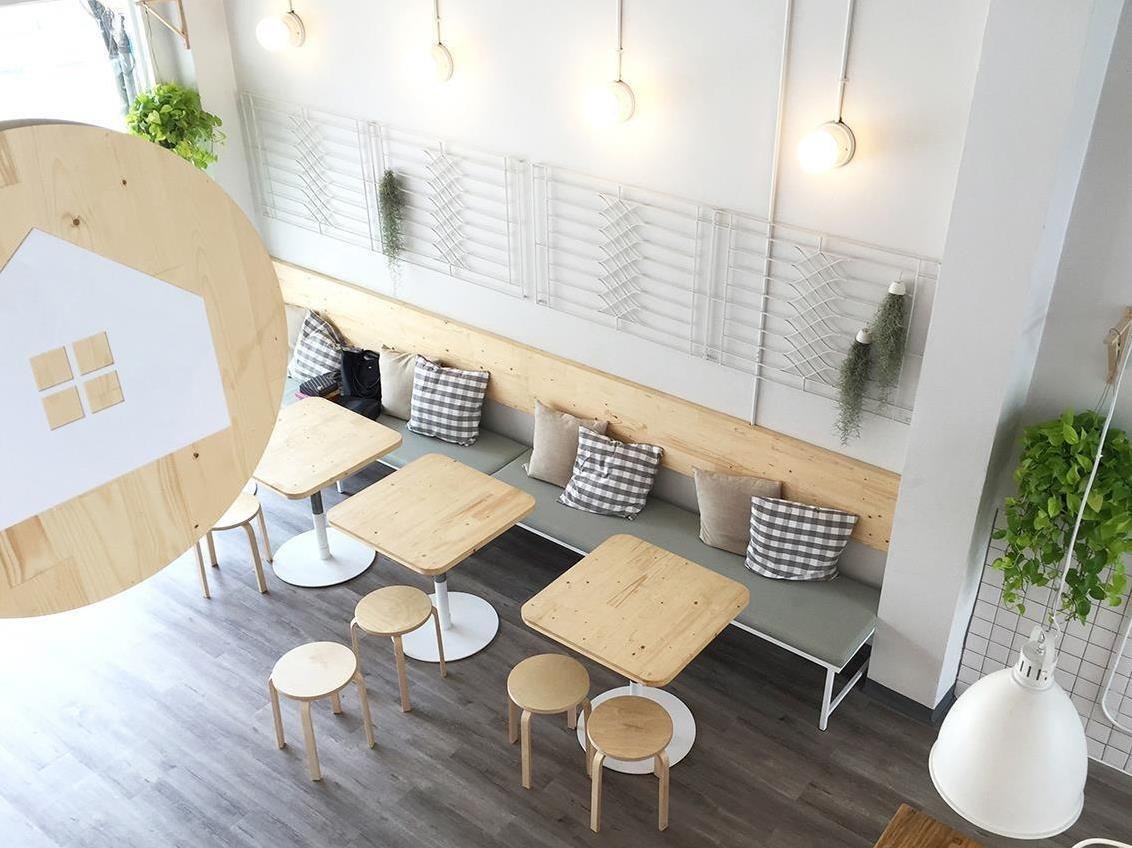 Bright common seating area with small tables at Movylodge Hostel