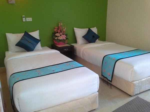 Twin beds in a Pentip Resort room with a green wall