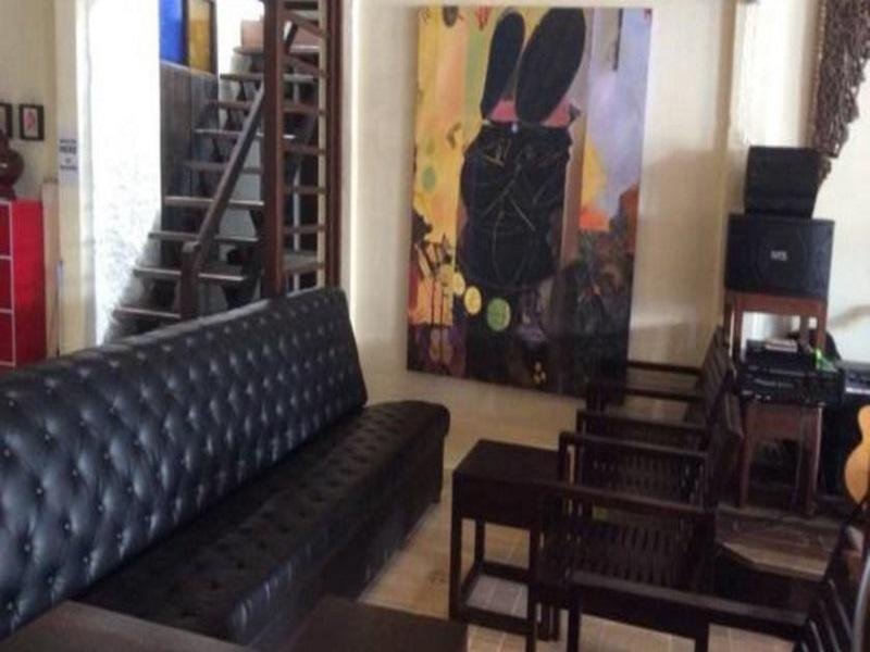 Sofa, chairs and artwork in the common room at Thapae Backpackers Hostel