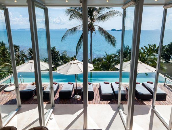 Sea-view pool terrace seen through glass doors at Villa Beige